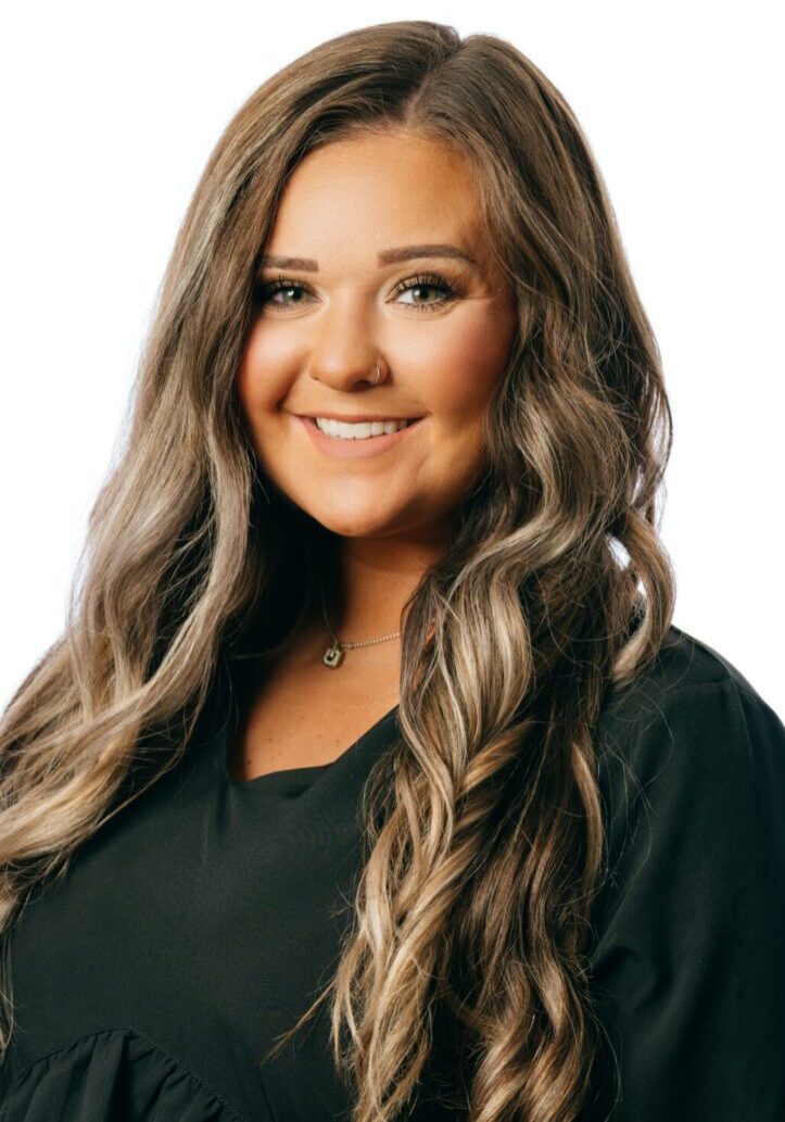 Smiling woman with long wavy hair.